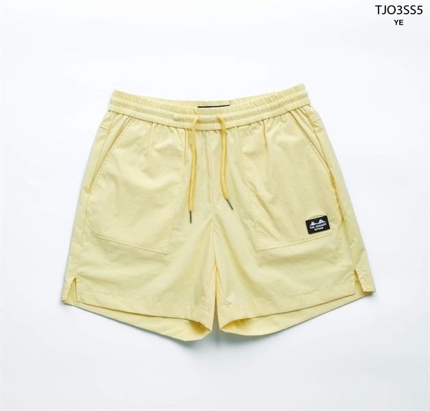 Pale yellow elastic-waist shorts with matching drawcord, front patch pockets and split hem, flat lay on white