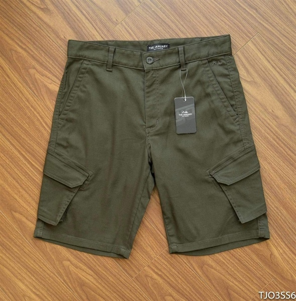 Olive cargo shorts laid flat on a wooden floor, front view with flap side pockets and a hang tag
