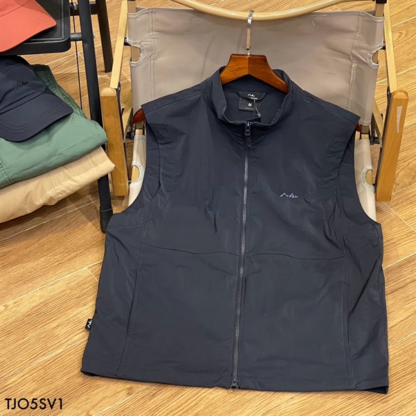 Áo gile khoá kéo màu xanh navy, cổ đứng, logo nhỏ ở ngực, treo móc gỗ trên ghế xếp