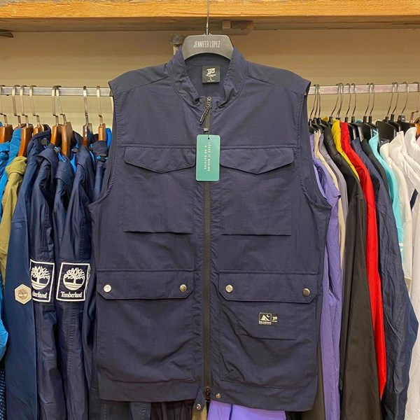 Áo gile cổ đứng màu xanh navy treo móc, khoá kéo giữa, bốn túi hộp nắp lớn phía trước