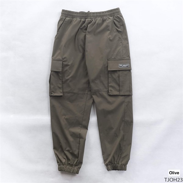 Quần jogger túi hộp màu xanh rêu trải phẳng mặt trước, cạp chun, hai túi hộp bên, gấu bo chun
