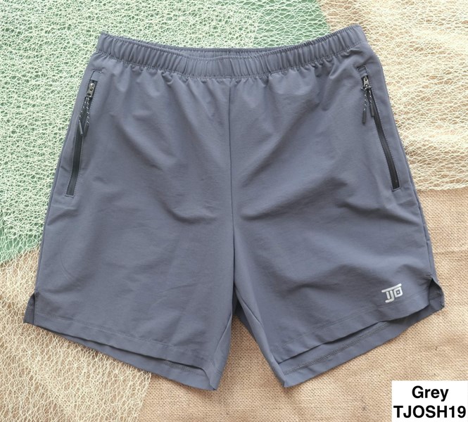 Grey shorts laid flat on netting and burlap, with elastic waist, zip side pockets and a small logo on the leg